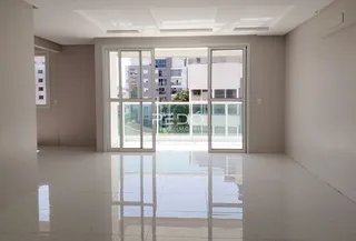 Sala ampla com piso claro e portas de vidro que dão para o exterior.