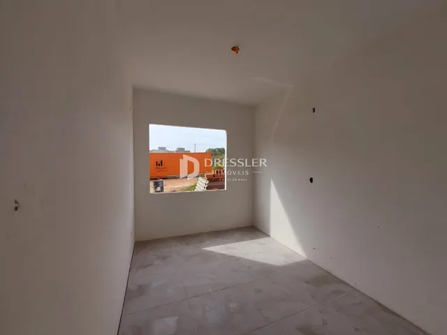 Interior de um ambiente com paredes brancas e piso claro.