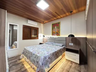 Quarto com cama grande e painel de madeira na parede.