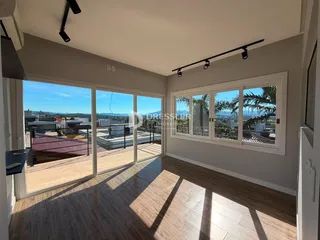 Sala de estar com portas de vidro que dão para uma área externa iluminada.