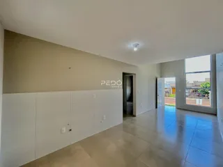 Interior de um espaço amplo com paredes brancas e piso claro.