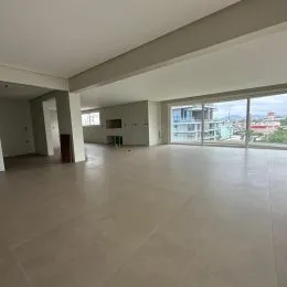 Ambiente interno amplo com piso claro e vista externa.