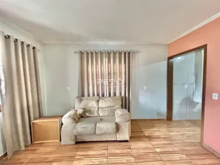 Sala de estar com sofá e cortinas em um imóvel no Brasil.