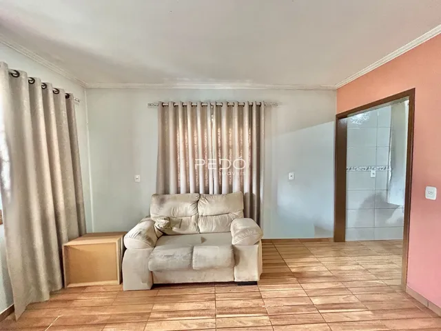 Sala de estar com sofá e cortinas em um imóvel no Brasil.