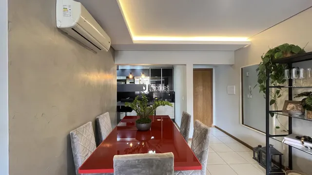 Sala de jantar com mesa vermelha e cadeiras em um imóvel em Lajeado.