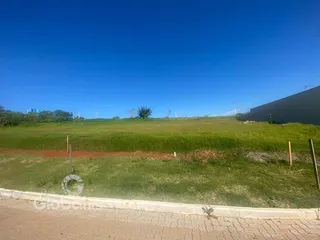 Vista de um campo gramado sob um céu azul.