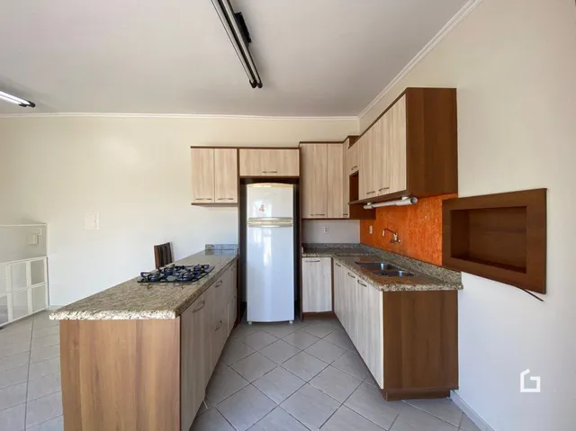 Foto de uma cozinha com armários de madeira e bancada clara.