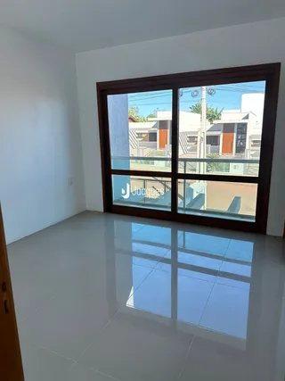 Vista da sala de um imóvel em Lajeado, Brasil, com grandes janelas de vidro.