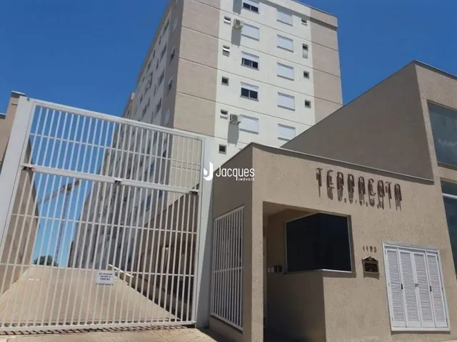 Fachada de um edifício residencial com grade de metal na frente.
