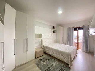 Quarto com cama e armários brancos em um imóvel no Brasil.