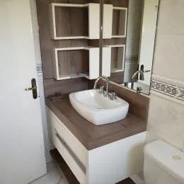 Foto de um banheiro com bancada e pia branca.