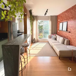 Sala de estar com piso de madeira e parede de tijolos aparentes.