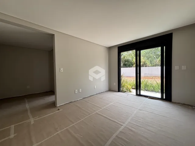 Vista interna de um cômodo com paredes brancas e piso cru.