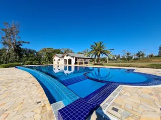 Vista externa de uma piscina com deck de pedra em Lajeado.