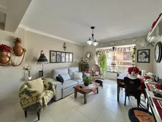 Sala de estar com sofá e mesa de jantar em um imóvel no Brasil.
