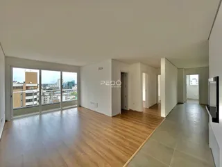 Sala de estar com piso de madeira e vista da cidade.