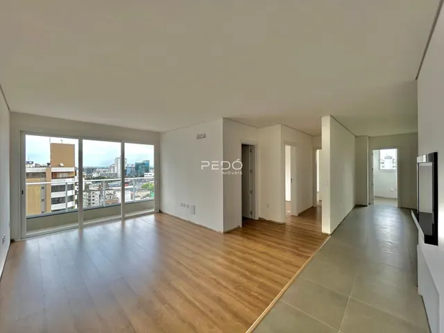 Sala de estar com piso de madeira e vista da cidade.