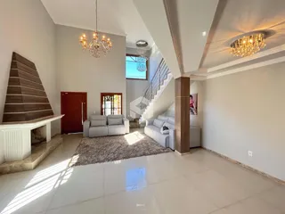 Sala de estar ampla com piso de porcelanato e lareira.