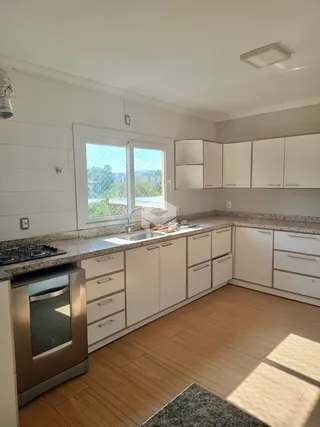 Foto de uma cozinha com armários brancos e piso de madeira clara.