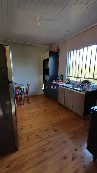 Ambiente interno de uma cozinha com piso de madeira.