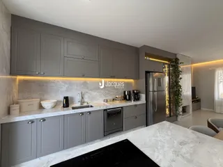 Cozinha moderna com armários cinzas e bancadas de mármore.