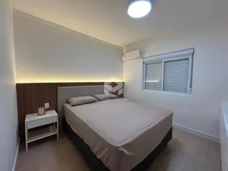 Quarto com cama e janela em ambiente claro.