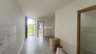 Hall de entrada com piso de cerâmica e paredes brancas.