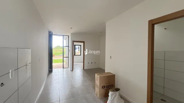 Hall de entrada com piso de cerâmica e paredes brancas.