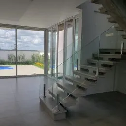 Foto de um interior com escadaria e grandes janelas de vidro.