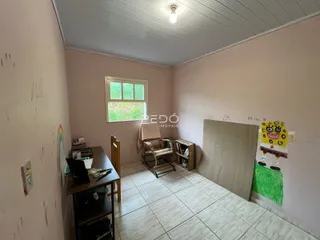 Quarto interno com piso de cerâmica e janela.