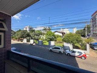 Vista externa de uma rua com casas e carros em Lajeado, Brasil.