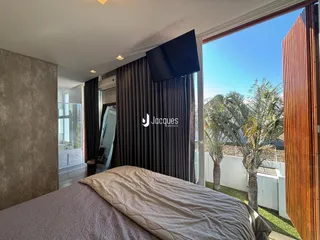 Quarto com vista para o jardim através de uma grande porta de vidro.