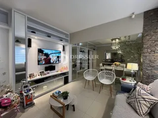 Sala de estar moderna com lareira e televisão em um imóvel no Brasil.