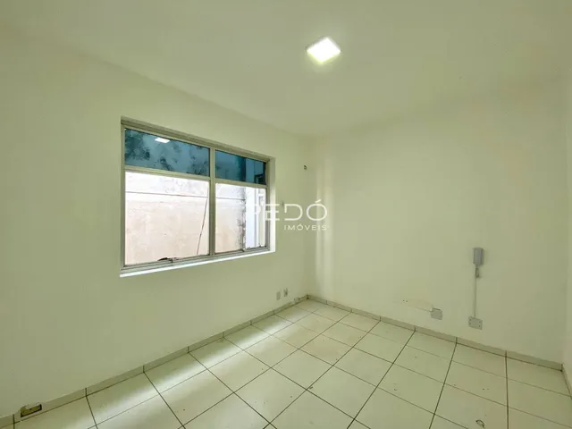 Interior de uma sala com piso de cerâmica clara e janela.