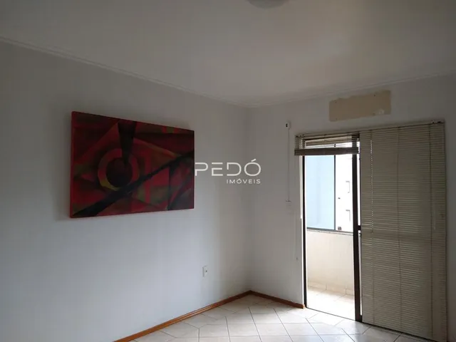 Sala de estar com paredes brancas e piso de cerâmica.