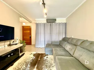 Sala de estar com sofá e televisão em um imóvel no Brasil.