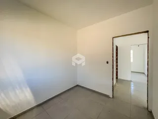 Vista interna de um cômodo com paredes brancas e piso de cerâmica.