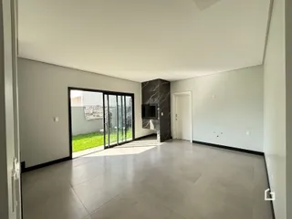 Sala de estar com piso de cerâmica e porta de vidro que dá para o quintal.