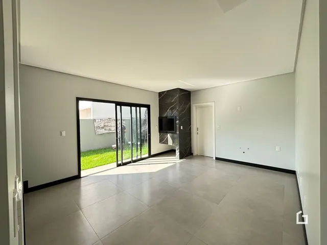 Sala de estar com piso de cerâmica e porta de vidro que dá para o quintal.