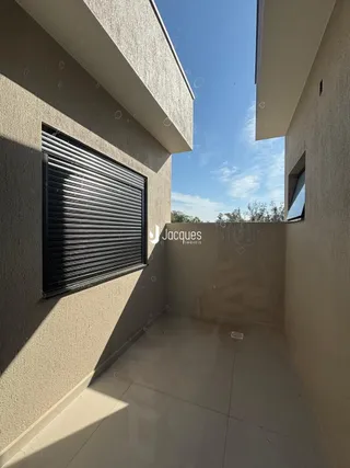 Vista de uma área externa com piso de concreto em uma residência.