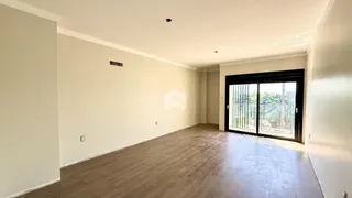 Interior de uma sala ampla com piso de madeira clara.