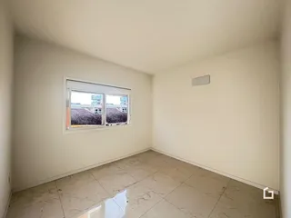 Foto de um cômodo interno com paredes brancas e piso de cerâmica.