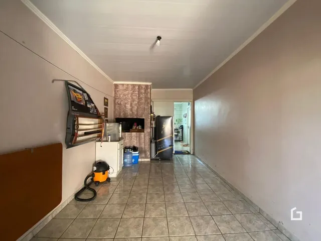 Corredor interno com piso de cerâmica e parede texturizada.