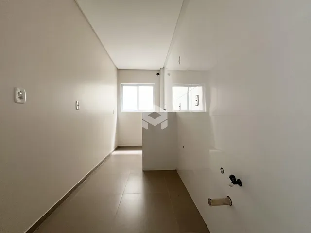 Corredor interno de uma residência com paredes brancas.