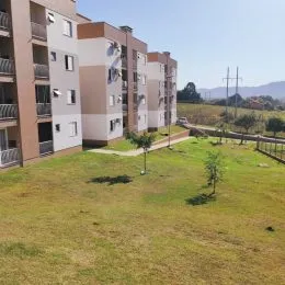 Vista de um gramado com colinas ao fundo.