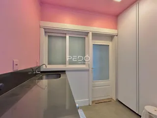 Vista de um ambiente interno com paredes rosa e um balcão de bancada.
