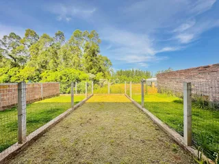 Vista de um terreno com cerca de arame e grama no Brasil.