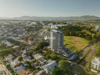 Vista aérea de uma área residencial em Lajeado, Brasil, mostrando casas e um grande edifício moderno.
