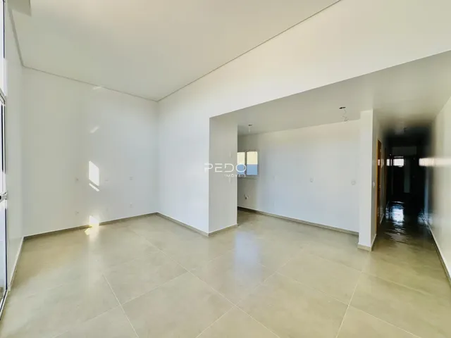 Interior de um ambiente com piso de cerâmica clara e paredes brancas.