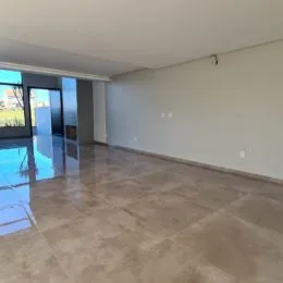 Foto de um ambiente interno amplo com piso claro e paredes brancas.